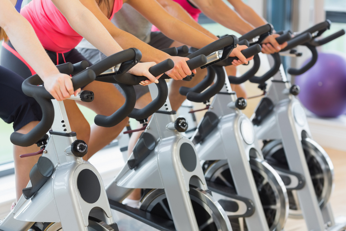 a group of people on stationary bikes in a gym